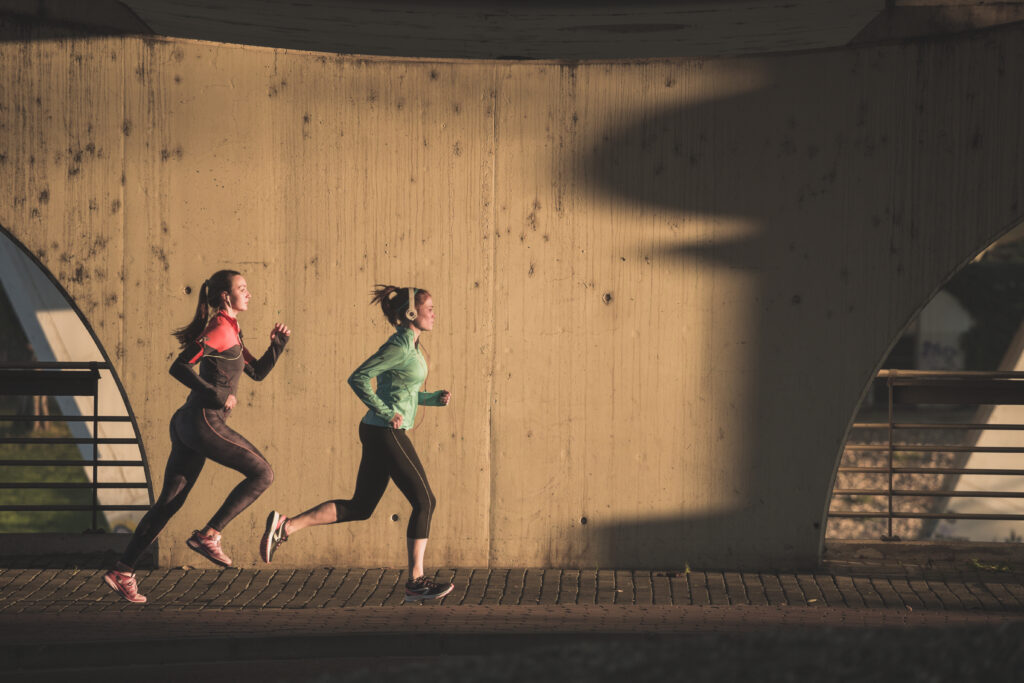 sportswomen running sunset